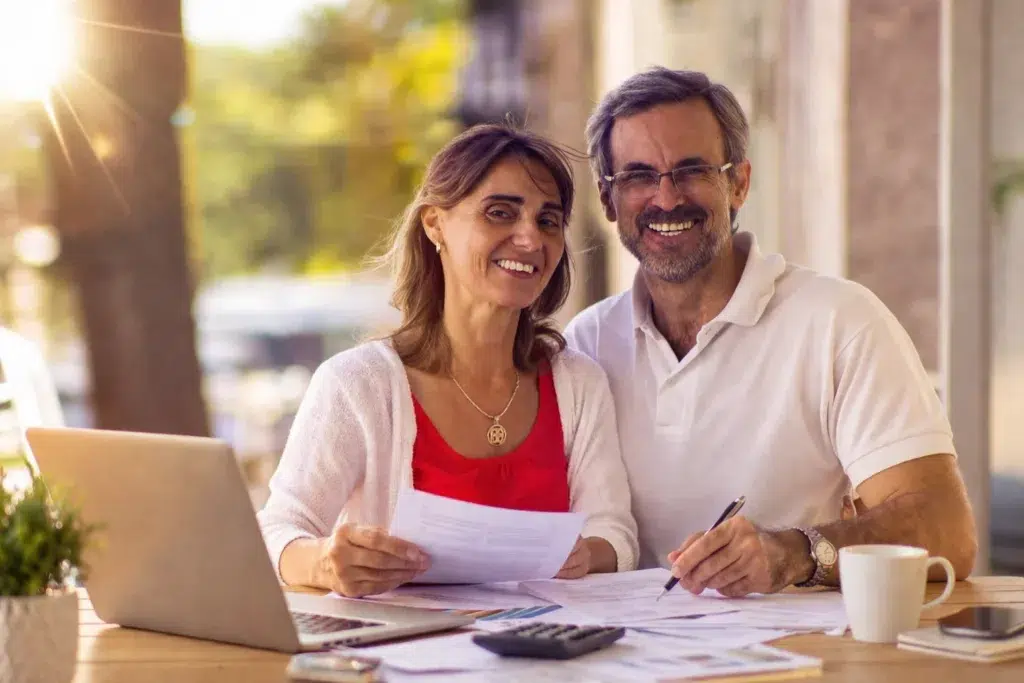 Couple de propriétaires salariés examinant des documents pour réduire leurs mensualités
